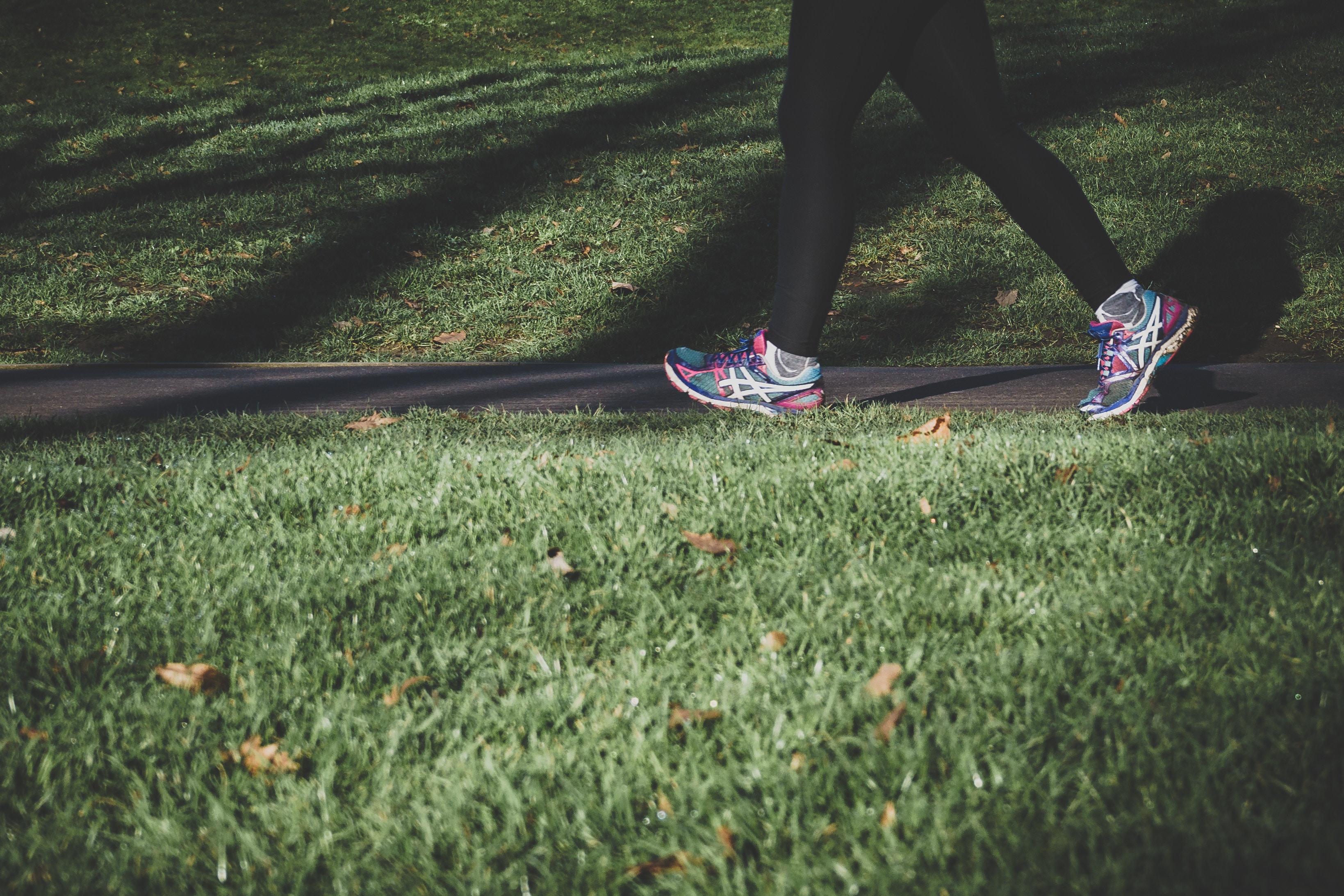 Läufer auf Weg im Gras, Beine und Schuhe im Bild